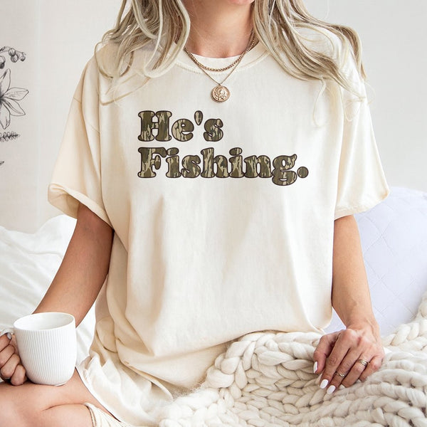 He's Fishing T-Shirt | Camo Lettering Graphic Design | 100% Premium Cotton Tee | Gift for Fisherman Angler Outdoorsman
